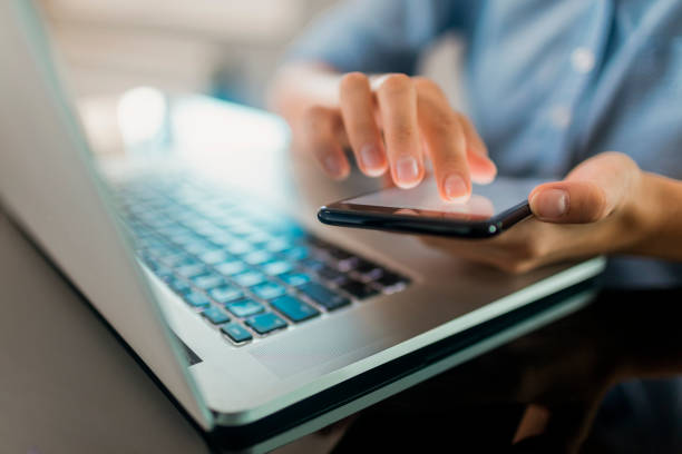 Person using a smartphone and laptop, indicating mobile payments and online banking in Dubai with UnionPay.