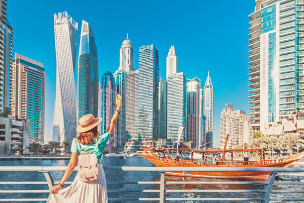 Woman overlooking Dubai skyline and traditional boat, representing opportunities for freelancers.