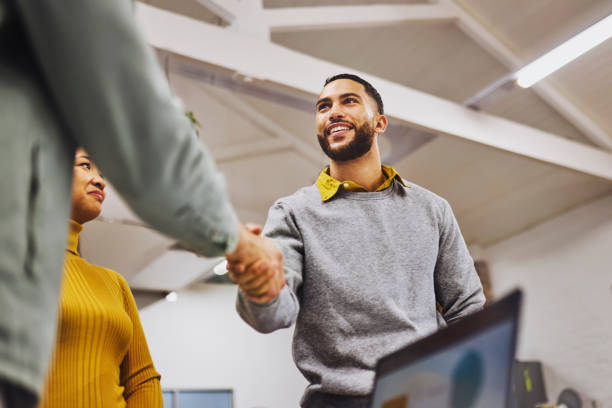 People shaking hands in an office, signifying welcoming foreign employees in Dubai.